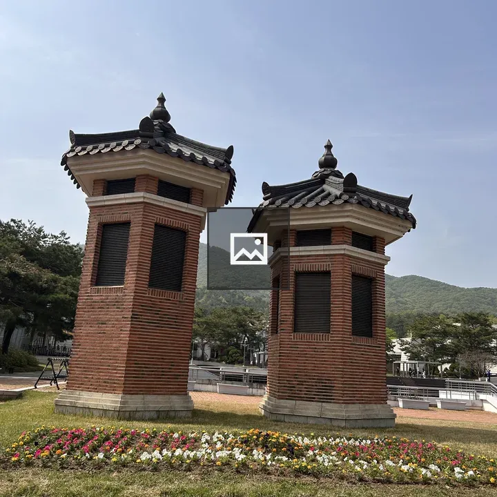 Two brick structures with pointed roofs