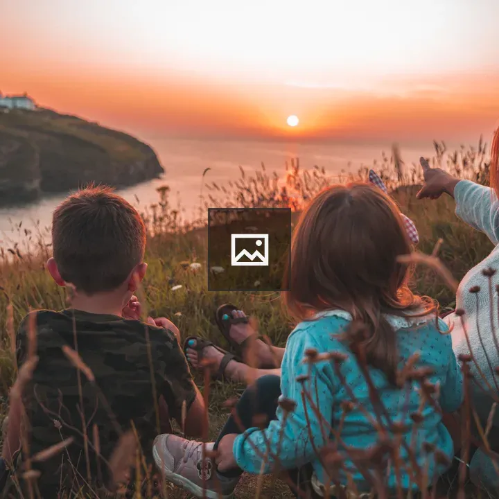 Family at Sunset Over Cliff