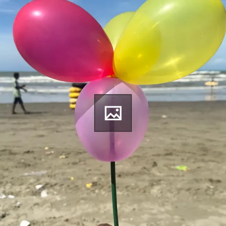 Hand with balloons at the beach