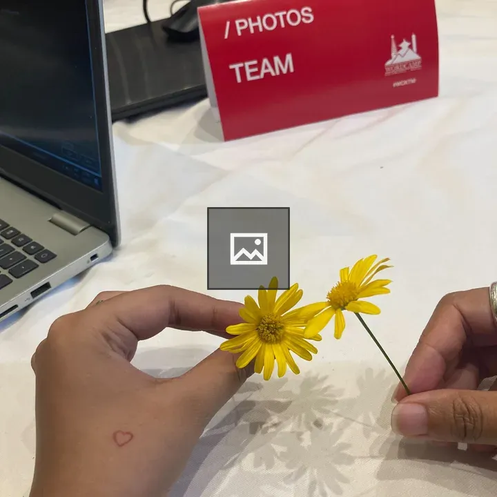 Two hands holding yellow flowers