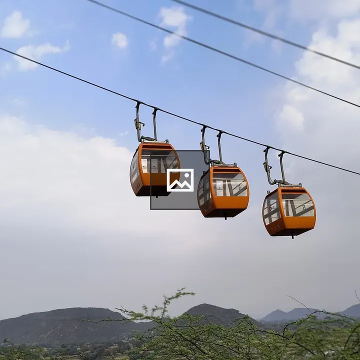 Three orange cable cars in mountains