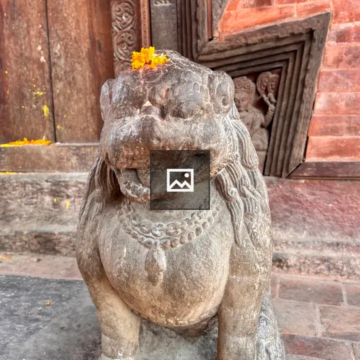 Stone lion statue with marigold flowers