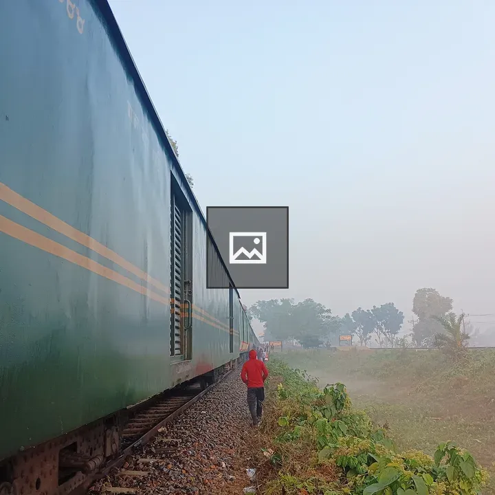 Long green train car by tracks