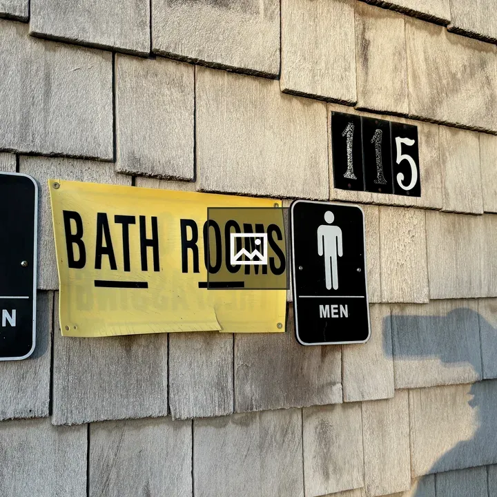 Yellow Bath Room Sign on Wall