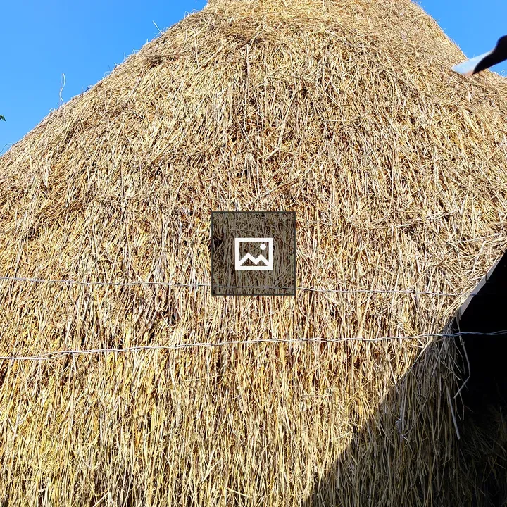 Tall haystack against blue sky