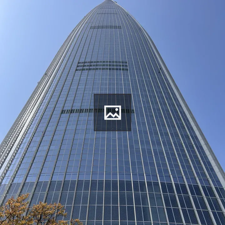 Tall glass tower against blue sky