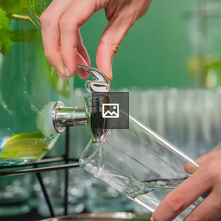 Woman pouring water from dispenser