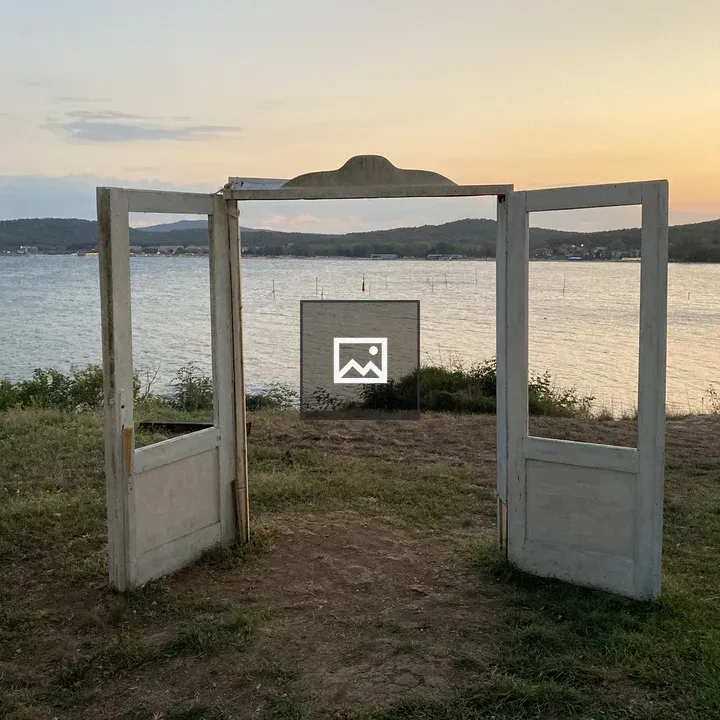 Pair of open white doors by water