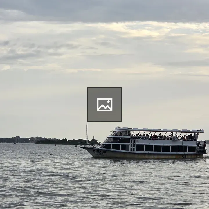 Boat on water under cloudy sky