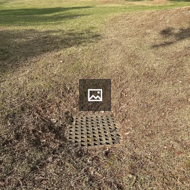 Rectangular metal grate in grass