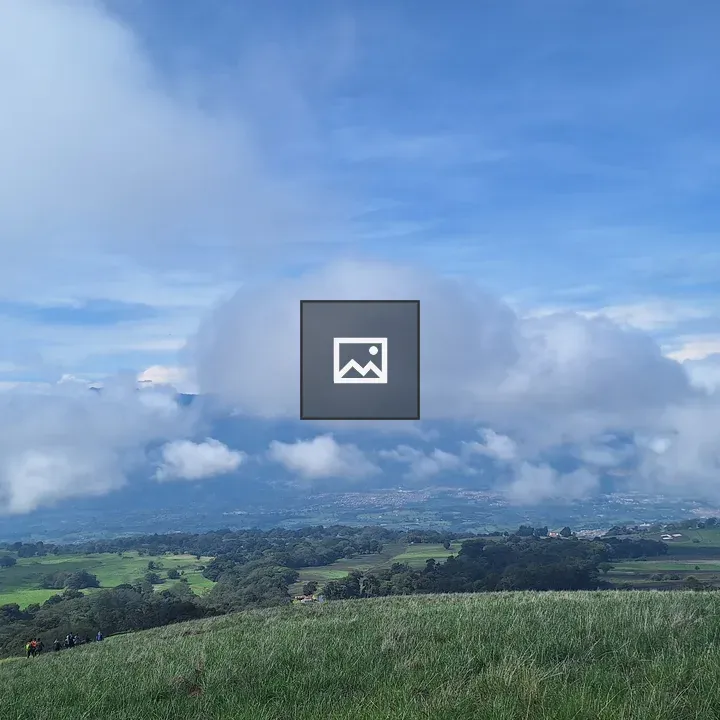 Hikers on a grassy hill in Costa Rica