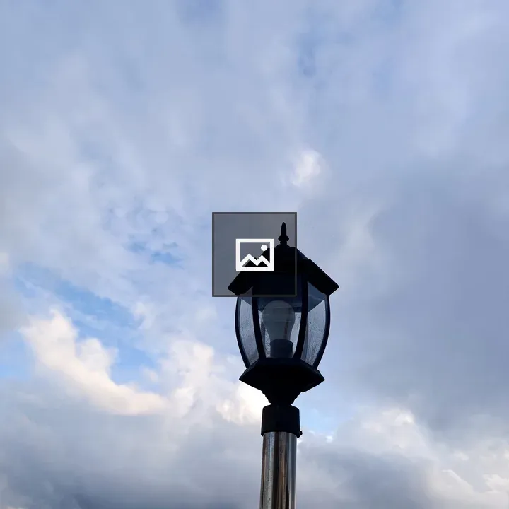 Lamp atop a post against the sky