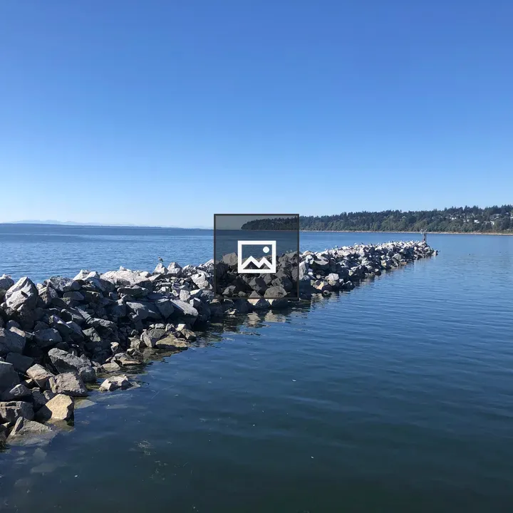 Rocky Breakwater Over Blue Water