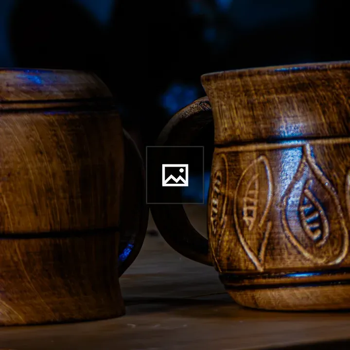Two wooden mugs on surface