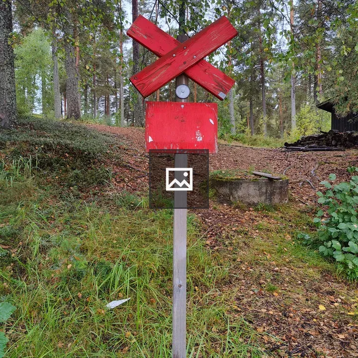 Red Signpost in Forest Clearing