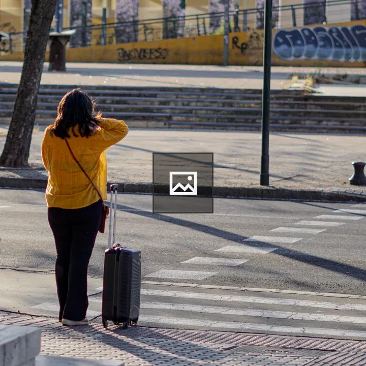 Woman with Suitcase on Sidewalk