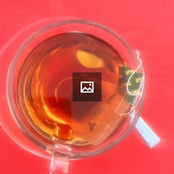 Cup of black tea on red table