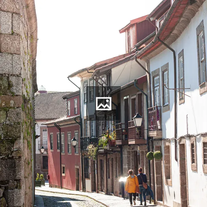 Two people on cobblestone street in Porto