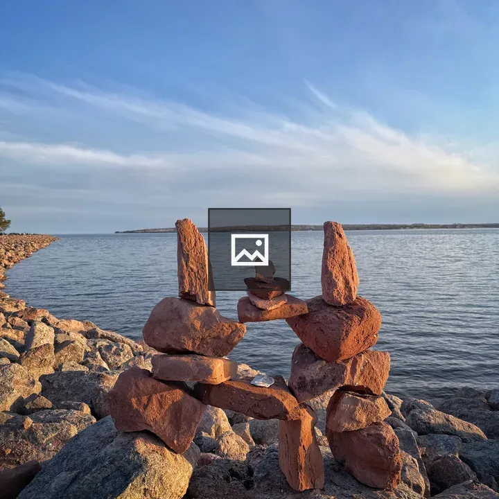 Balanced cairn at rocky lakeshore