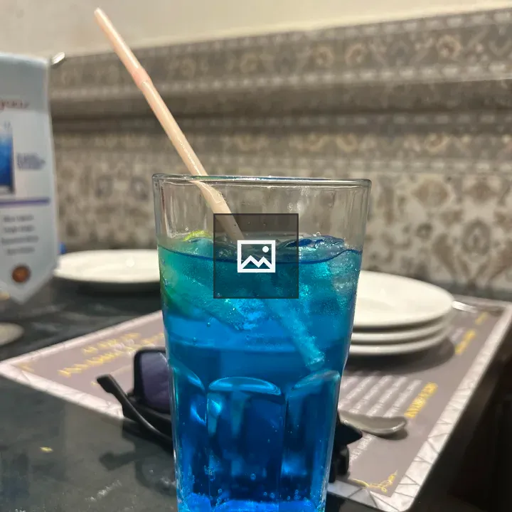 Blue beverage with lemon garnish