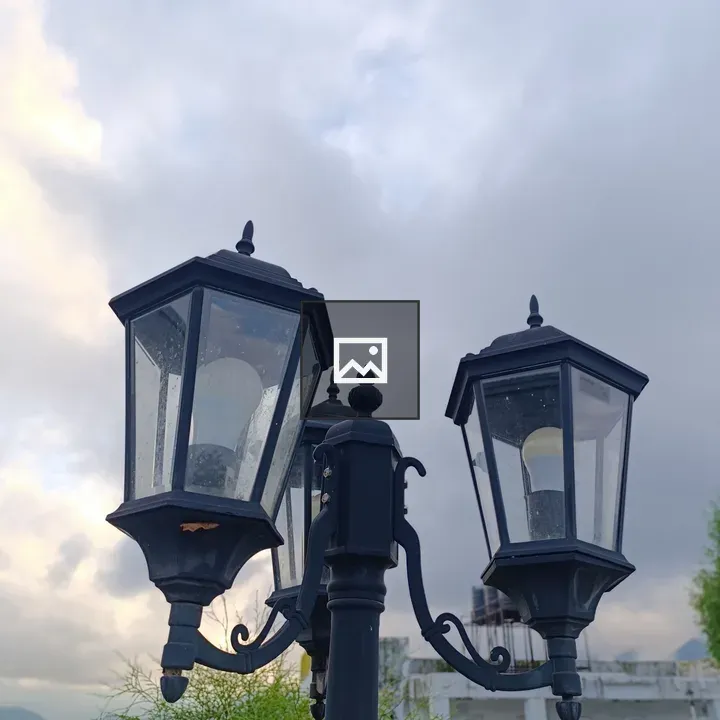 Black vintage lamp post with three lanterns
