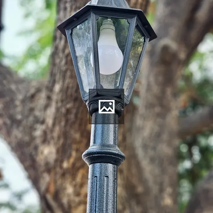 Black street lamp with tree backdrop