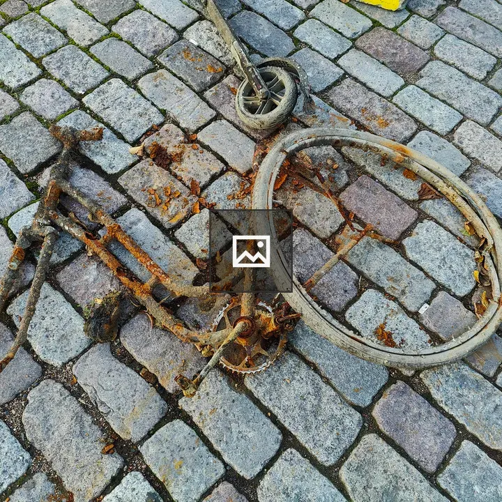 Rusty bicycle frame on cobblestones