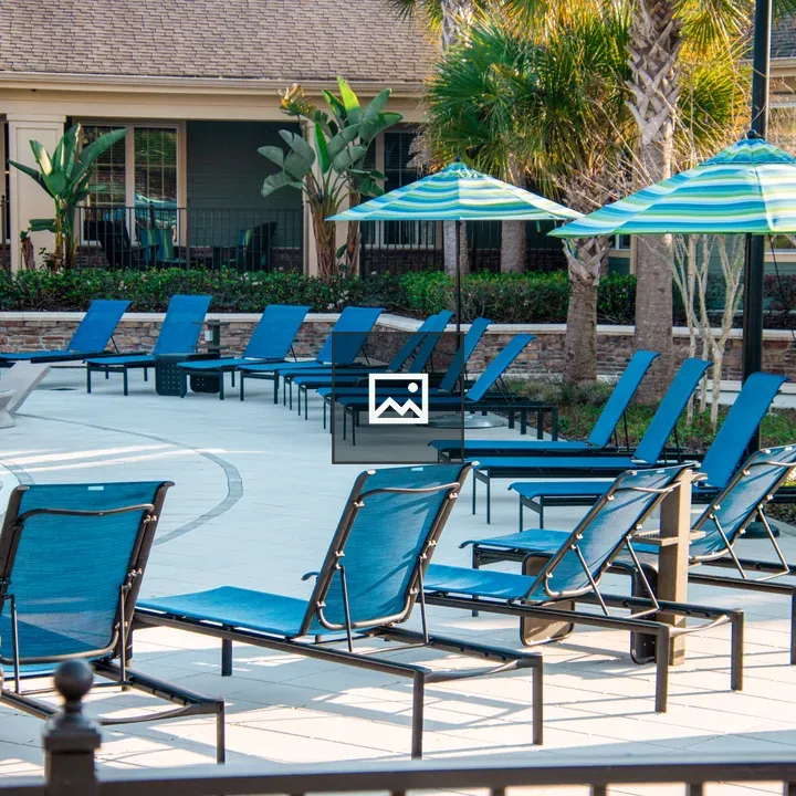 Empty lounge chairs by pool deck