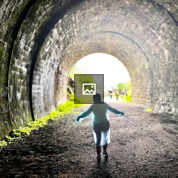 Person walking toward light in tunnel