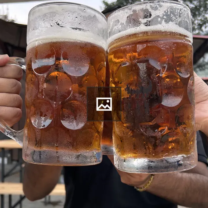 Two frosty beer mugs clinking