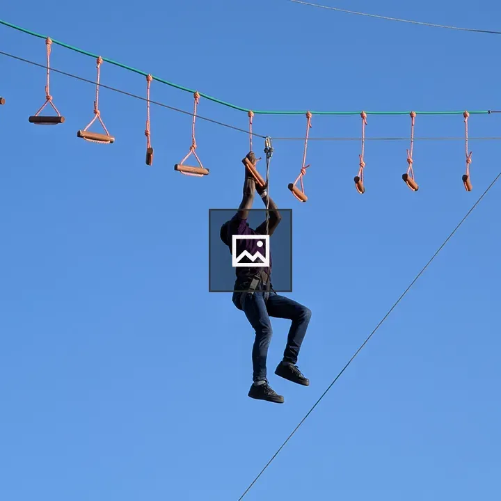 Rope course participant in blue sky