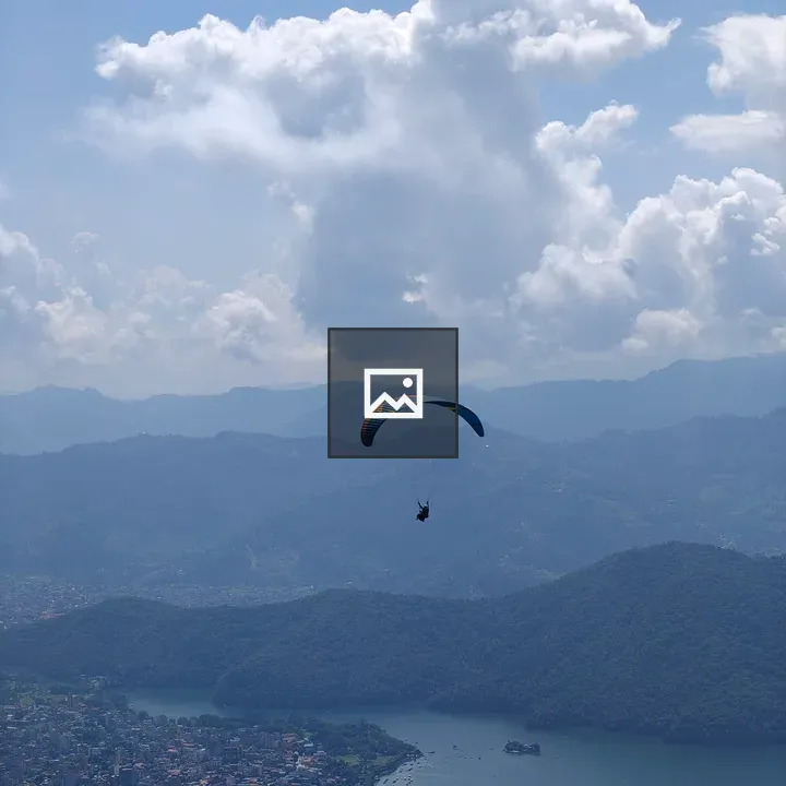 Paraglider over lake town