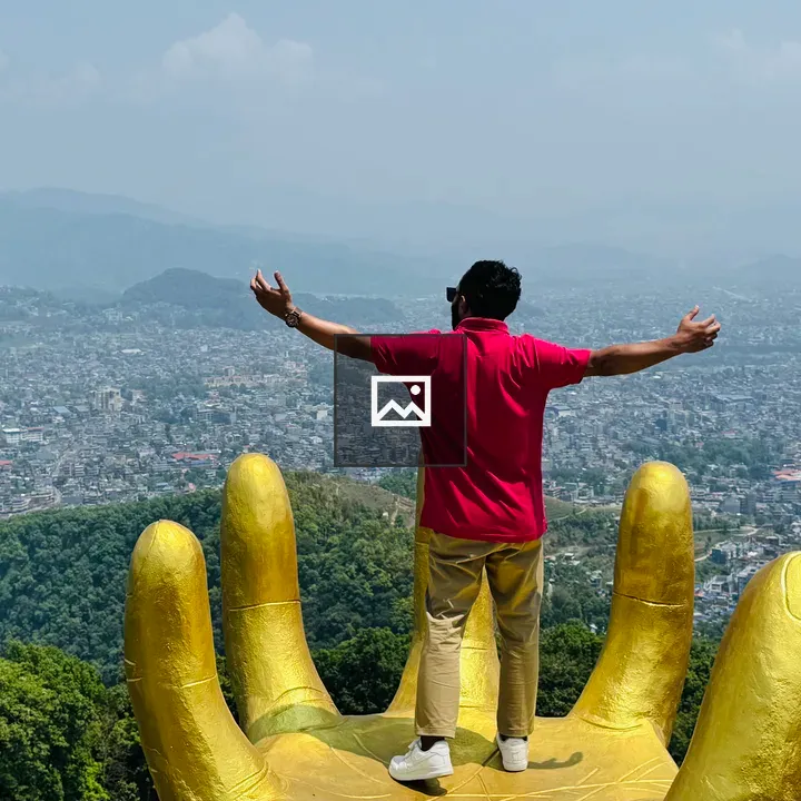 Person on Large Golden Hand Sculpture