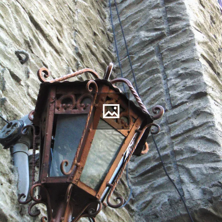 Brown electric lantern on rock wall