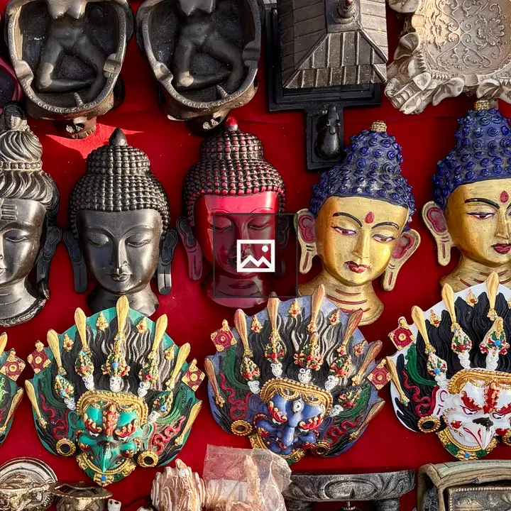 Decorative Buddha and deity masks on red fabric