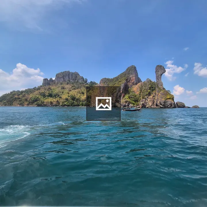 Rocky island and boat on calm sea