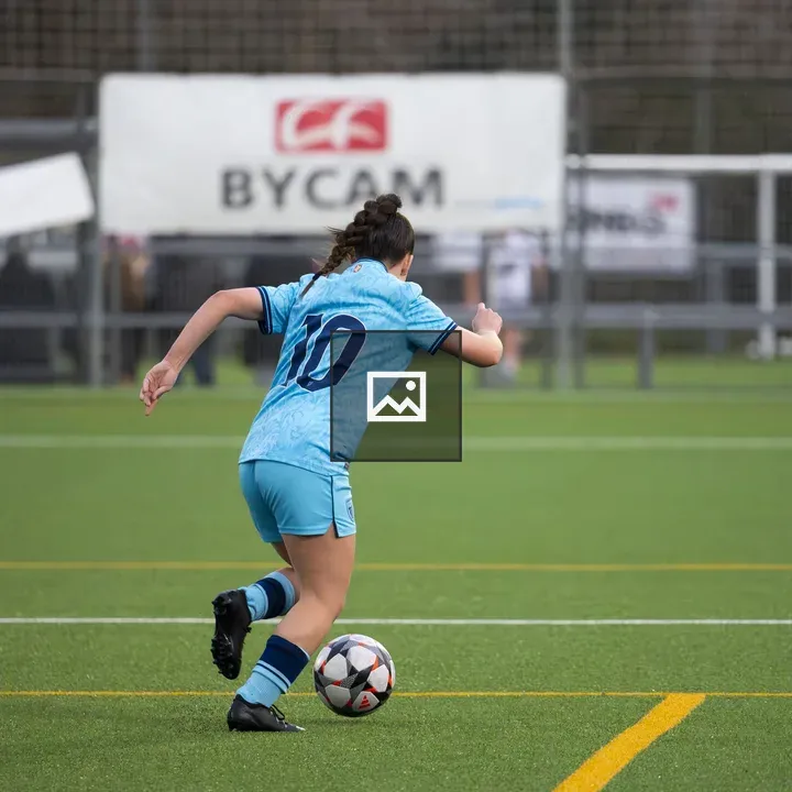 Female soccer player running with ball