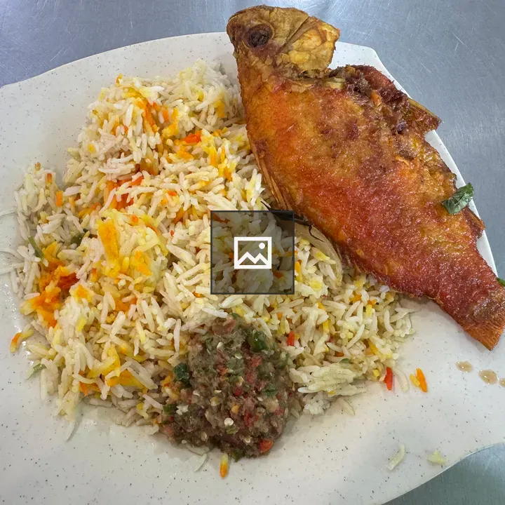 Plate with colorful rice and fried fish
