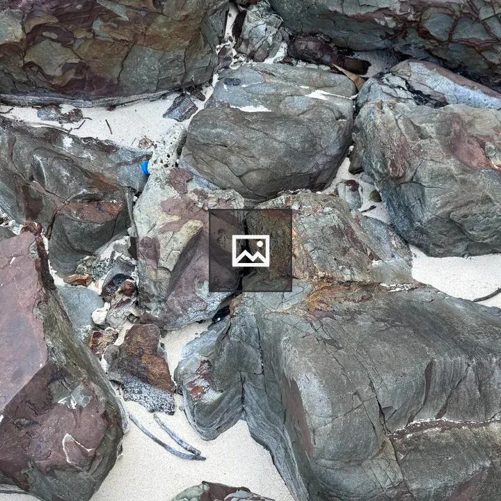 Rocks on White Beach Sand