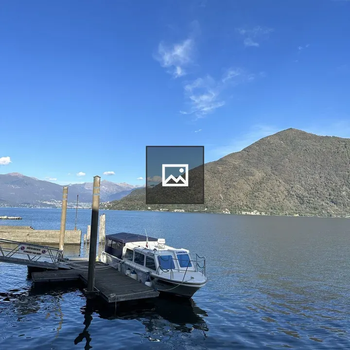 Boat at Canobbio Dock with Mountain Backdrop