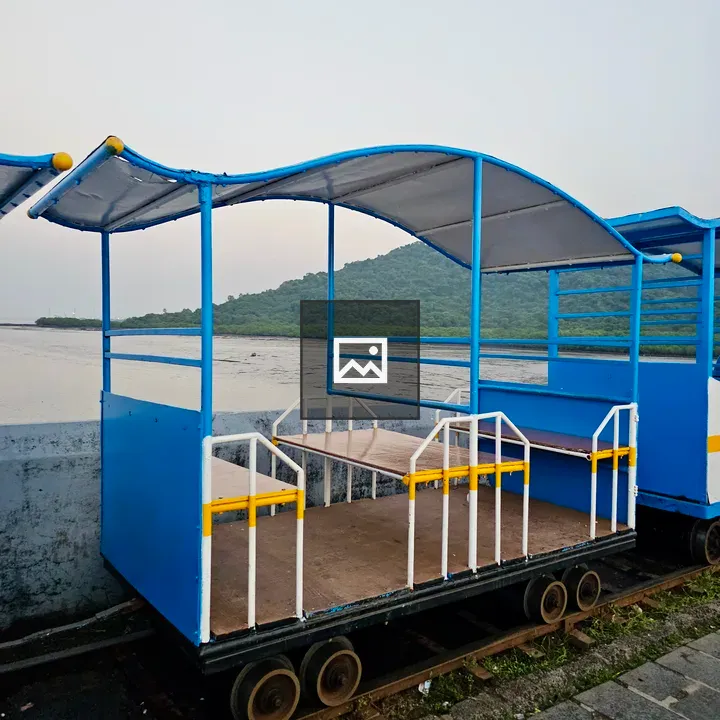 Blue mini train coach by water