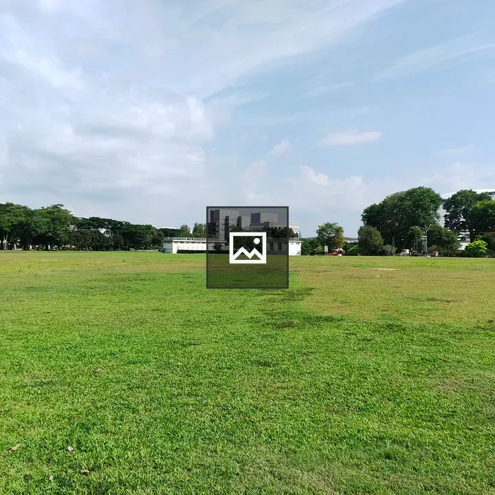 Grassy field with buildings in background