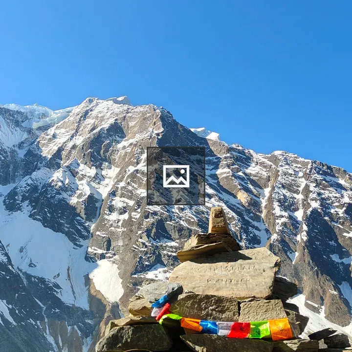 Cairn with Prayer Flags and Mountains