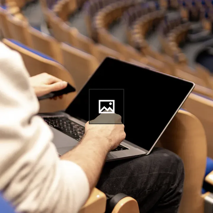 Man with Laptop in Auditorium