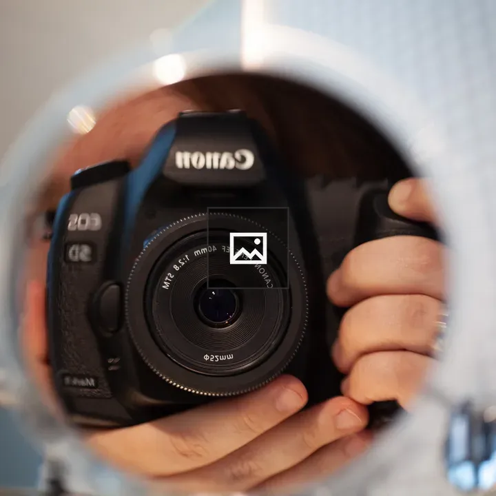 Canon camera in circular mirror