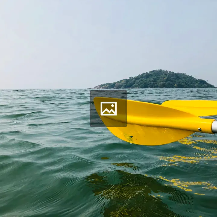 Yellow kayak paddles on calm water