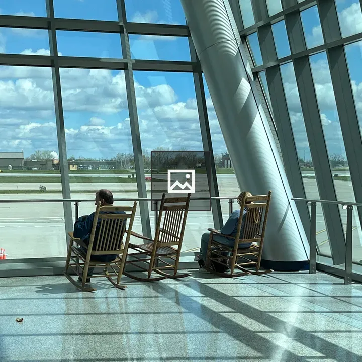 People in rocking chairs by glass walls