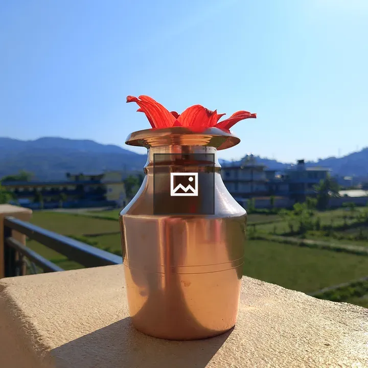 Copper vessel with flower on balcony