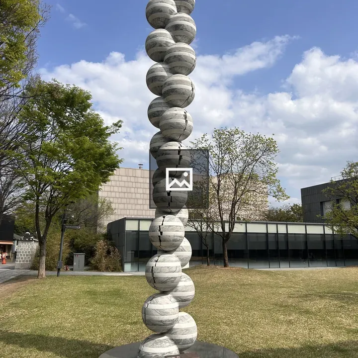 Tall stone sculpture with stacked spheres