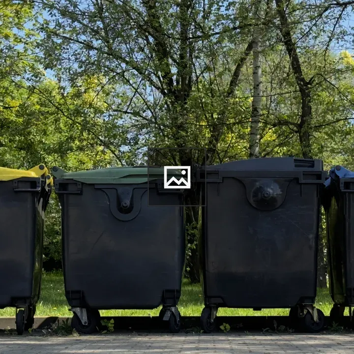 Four waste trash cans in greenery